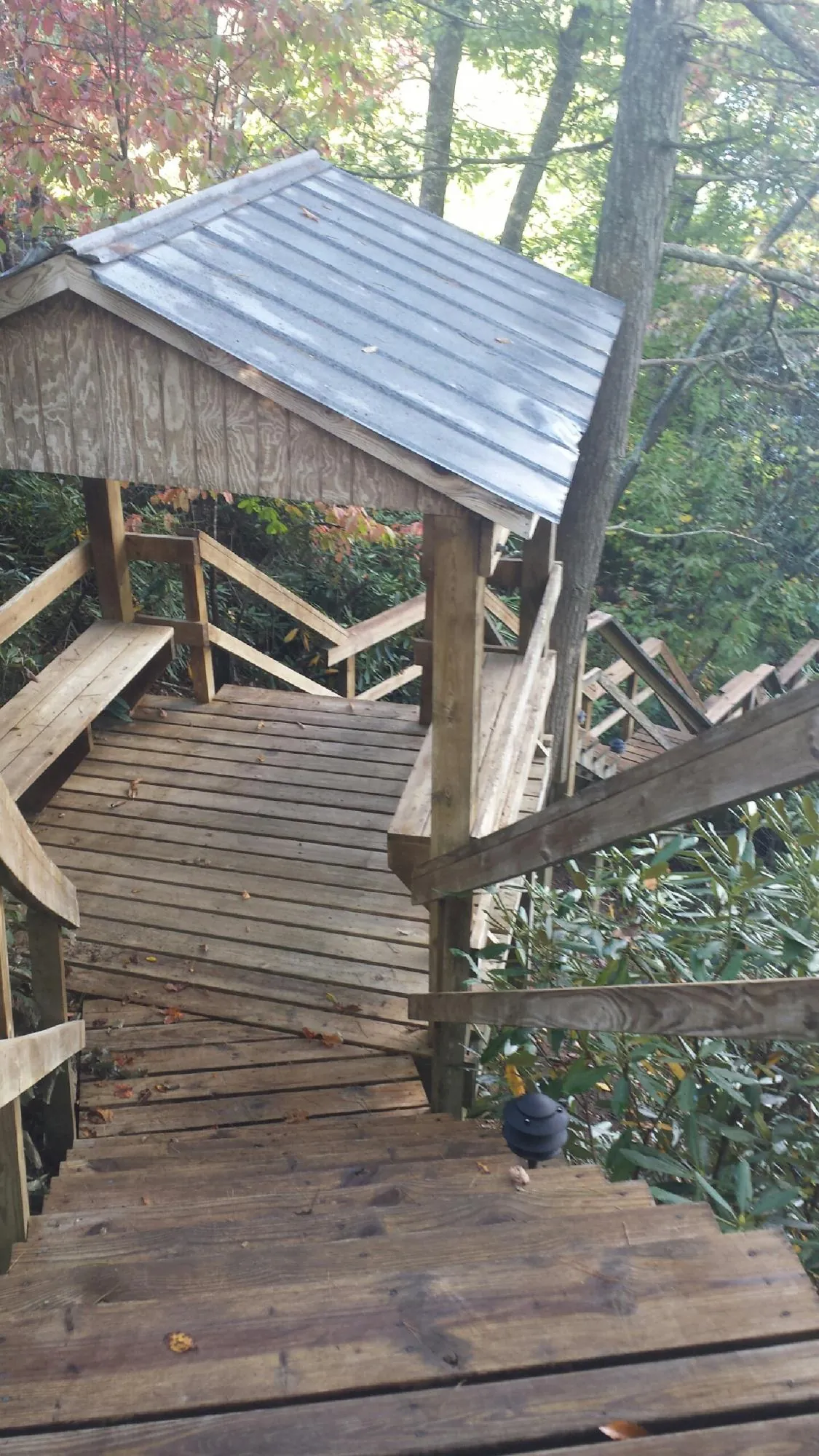 Metal roofed shelter over wooden steps on a wooded walkway — Skylight Repair & Installation work by our crew in Wheeling