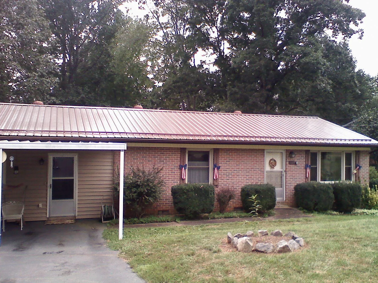 Bronze metal roof and carport on a brick ranch home — Roof Repair work by our crew in Wheeling